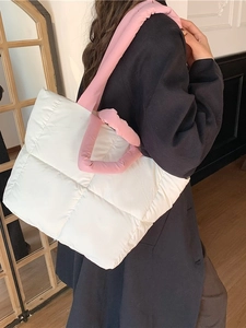 Quilted white puffer tote bag with fluffy pink handles styled on a black blazer