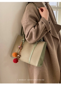 Detail der minimalistischen gewebten Tasche mit grünem Lederbesatz und bunten Anhängern