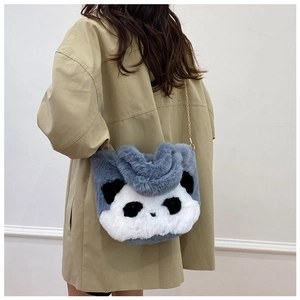Sac peluche panda avec chaîne dorée porté sur un manteau kaki pour femme