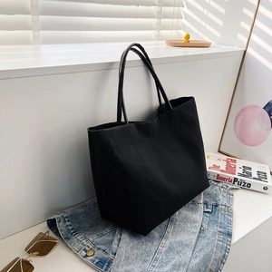 Detail shot of black canvas tote bag showing large capacity and textured fabric
