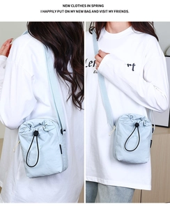 Vista frontale e posteriore di una borsa a tracolla in nylon azzurro con coulisse