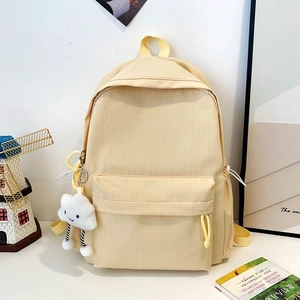Detail of yellow checkered backpack featuring side drawstring pockets and cloud plush charm