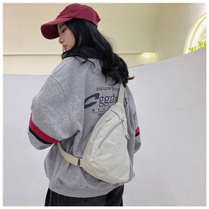 Detailed side view of off-white nylon crossbody bag showing adjustable metal buckle and texture
