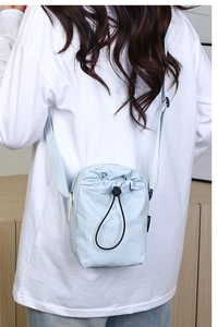 Dettaglio della borsa a tracolla in nylon verde menta con coulisse nera e tracolla regolabile