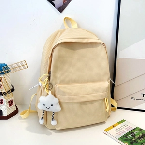 Detail of beige checkered backpack with a soft cloud pendant and spacious front pocket