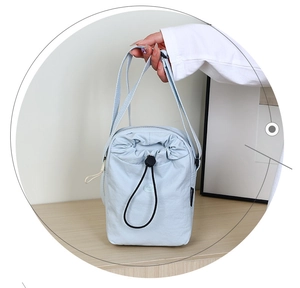Dettaglio borsa a tracolla in nylon azzurro con coulisse regolabile e fermaglio nero