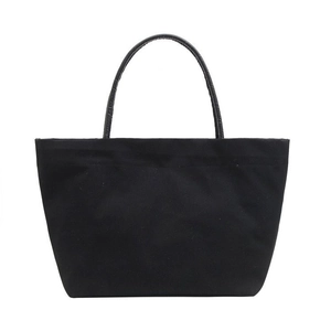 Minimalist black canvas bucket tote bag with crocodile embossed leather handles