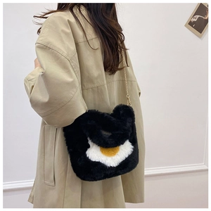 Detail view of plush egg-shaped handbag with soft faux fur texture and gold chain strap