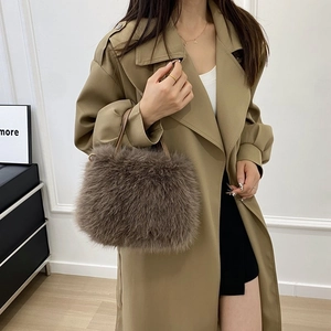 Dettaglio borsa in peluche marrone scuro con catena di perle e manico in pelle da donna