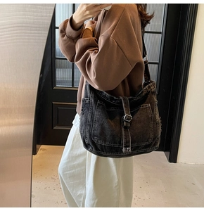 Detail showing high-density washed denim fabric and functional utility pockets of the bag