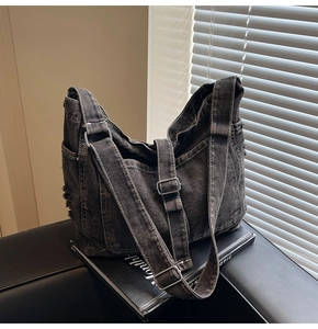 Detail of vintage washed denim tote bag showing multiple pockets and frayed edge design