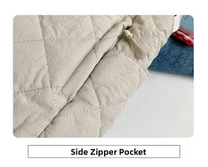 Detail of beige quilted tote bag showing the side zipper pocket and rhombic stitching