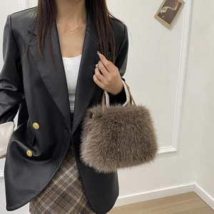 Dettaglio di una borsa marrone in pelliccia sintetica con eleganti accenti dorati
