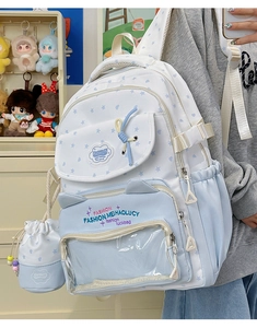 Detail of cute cat-ear student backpack with star prints and a round coin purse pendant