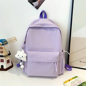 Close-up of light purple checkered backpack with a white cloud plush keychain accessory