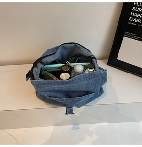 Internal view of a spacious washed denim tote bag showing items for daily organization