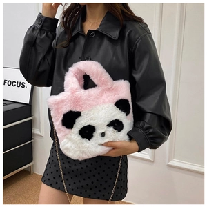 Détail du sac en peluche panda rose avec bandoulière en chaîne dorée porté par un modèle