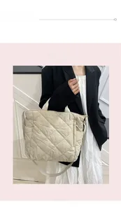 Quilted tote bag in cream white showing large capacity and shoulder strap on model