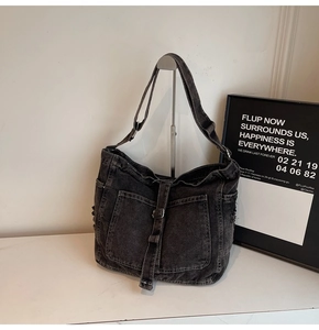 Detail of vintage washed charcoal denim tote bag with cargo pocket and metal buckle