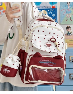 Detailed view of canvas backpack featuring red stars print and matching small coin pouch