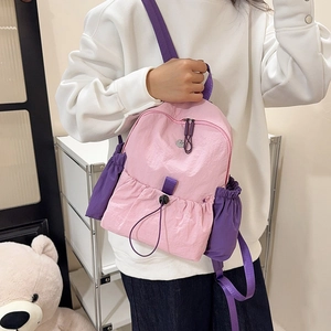 Detailansicht aus rosa wasserfestem Nylon-Rucksack mit lila Trägern und Kordelzugverschluss