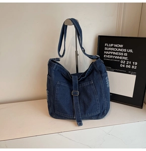 Close-up of vintage washed denim tote bag with large front pocket and frayed edges
