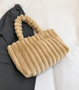 Detail of khaki plush tote bag featuring vertical striped texture and unique ball handle