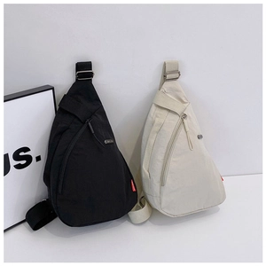 Detail view of nylon crossbody sling bags with adjustable straps in black and beige tones