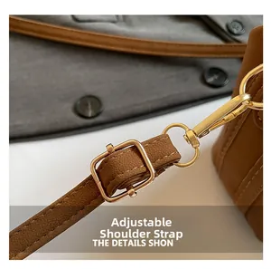 Détail de la bandoulière réglable en cuir marron avec boucle en métal doré brillant