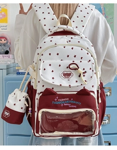 Detail of cute school backpack with heart star patterns and transparent pocket for badges
