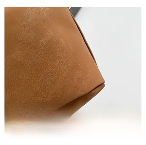 Gros plan détaillé montrant la texture du cuir marron et les coutures soignées du sac à main