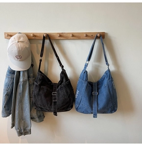 Detail of vintage washed denim tote bags in charcoal grey and blue with metal buckles