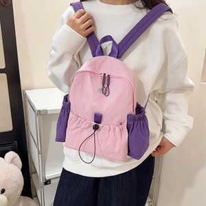 Detailansicht des pink-violetten wasserfesten Nylon-Rucksacks mit Seitentaschen am Modell