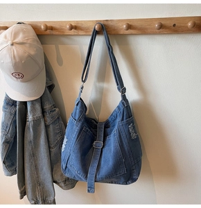 Detail of vintage washed denim tote bag showing distressed fabric texture and side pocket