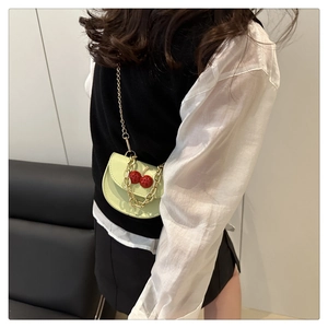 Mini sac bandoulière vert menthe avec détails de cerises et chaîne dorée en gros plan