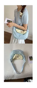 Close-up of light blue canvas crossbody bag with yellow pear embroidery and Pear text
