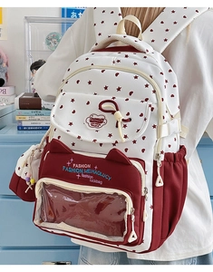 Detail of red and white school bag with cat ear design and clear PVC window insert