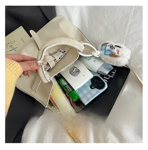 Top view of the spacious interior of a beige pleated handbag with daily essentials