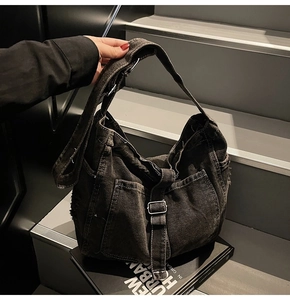 Detailed view of washed denim tote with distressed edges and metallic buckles