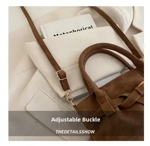 Detail of adjustable golden buckle and premium faux suede strap on brown tote bag