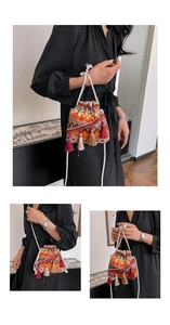 Detail einer Boho-Beuteltasche mit orangefarbenen Quasten und gewebtem Kordelzug aus Baumwolle