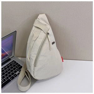 Detail of off-white nylon crossbody bag featuring a vertical zipper and red fashion label