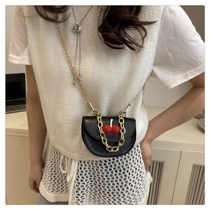 Détail du mini sac bandoulière en cuir noir avec cerise 3D et chaîne dorée