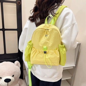 Detailansicht des gelb-grünen Rucksacks mit Kordelzug und wasserfestem Nylonmaterial