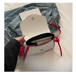 Detail view showing the spacious interior of blue plaid handbag with red leather trim