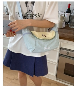 Detail of light blue nylon crossbody bag with pear embroidery and cute flap design