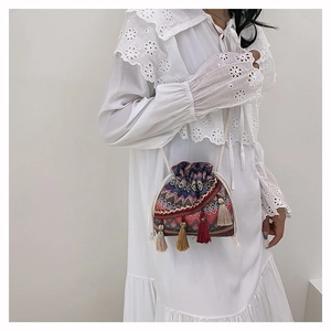 Detail der Boho-Beuteltasche mit geometrischer Stickerei und bunten Quastenanhängern
