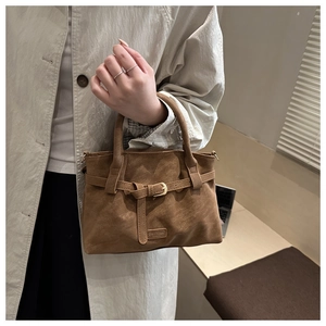 Detailed view of the brown suede tote bag featuring a decorative buckle and Fashion label