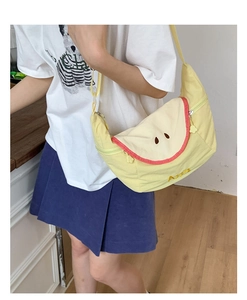 Detail view of macaron yellow apple shaped canvas crossbody bag with embroidery