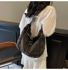 Detailed view of washed vintage denim tote bag with frayed edges and retro strap details